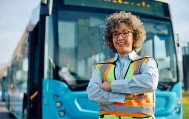 Confident female bus driver at the station looking at camera.