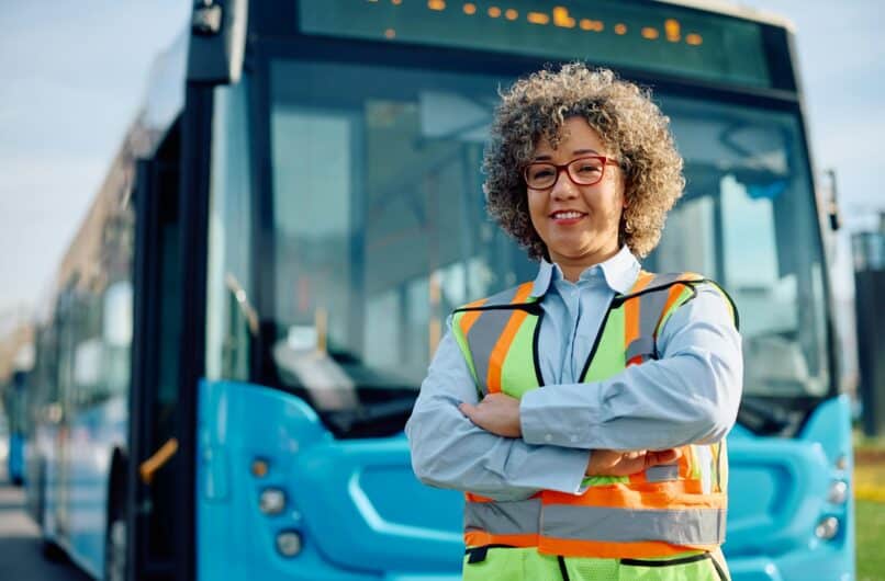 Confident female bus driver at the station looking at camera.